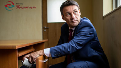 Мужчина прячет алкоголь в ящике стола